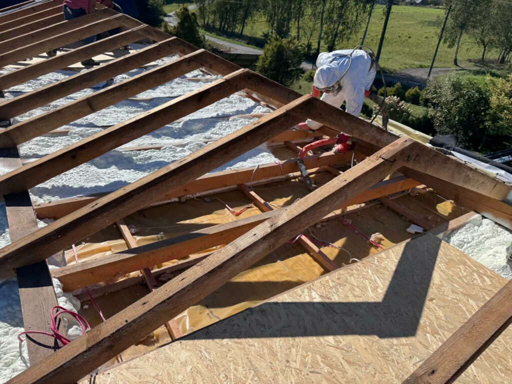 Montaż płyty OSB na konstrukcji dachu podczas wymiany ocieplenia poddasza